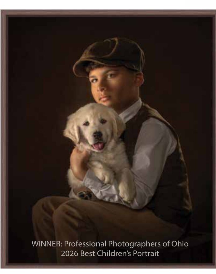 An award-winning pet portrait of a boy holding a golden retriever puppy